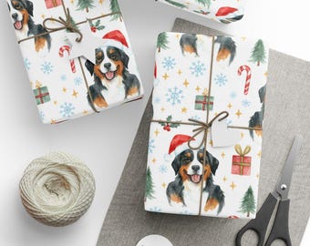 May include: Christmas-themed wrapping paper featuring a Bernese Mountain Dog wearing a Santa hat. The paper is decorated with snowflakes, Christmas trees, and gift boxes. Tied with twine and a blank tag, the scene includes scissors and a spool of twine.