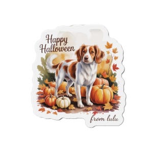 May include: A sticker featuring a dog standing among pumpkins and autumn leaves. The text "Happy Halloween" is at the top, with "from lulu" at the bottom. The dog is white and brown.