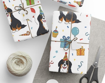 May include: Gift-wrapped presents with white paper featuring a Bernese Mountain Dog wearing a party hat, balloons, confetti, and gift boxes. Tied with twine and a star-shaped tag. A ball of twine, scissors, and tags are also visible.