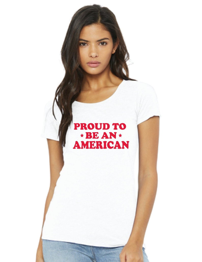 May include: White t-shirt with red text that reads "PROUD TO *BE AN* AMERICAN".