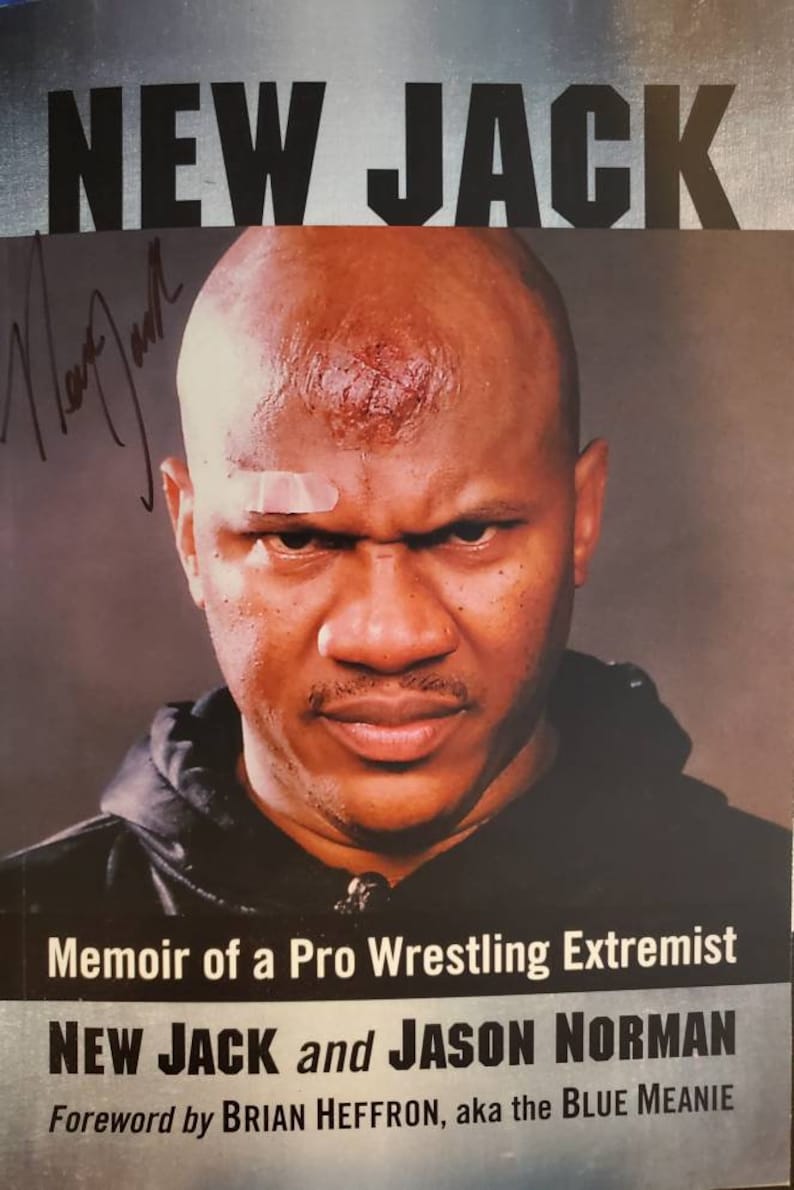 May include: A book cover with a black and white photo of a man with a shaved head. The title of the book is "NEW JACK" and the subtitle is "Memoir of a Pro Wrestling Extremist". The book is written by "NEW JACK and JASON NORMAN" with a foreword by "BRIAN HEFFRON, aka the BLUE MEANIE".