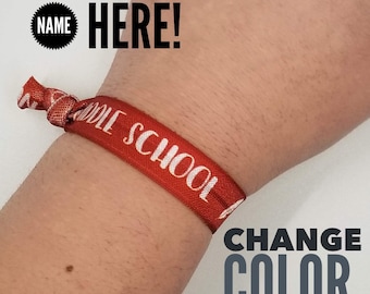 May include: Red wristband with white text that reads "Middle School". Text overlay on the image reads "Your School Name Here! Change Color, Add Mascot, and More!"