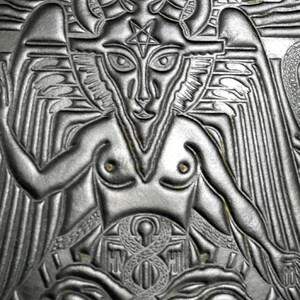 Peut inclure: Un motif en cuir gaufr&eacute; noir et blanc repr&eacute;sentant une figure ail&eacute;e avec un pentagramme sur le front. La figure est assise les jambes crois&eacute;es et a un motif en forme de serpent sur ses genoux.