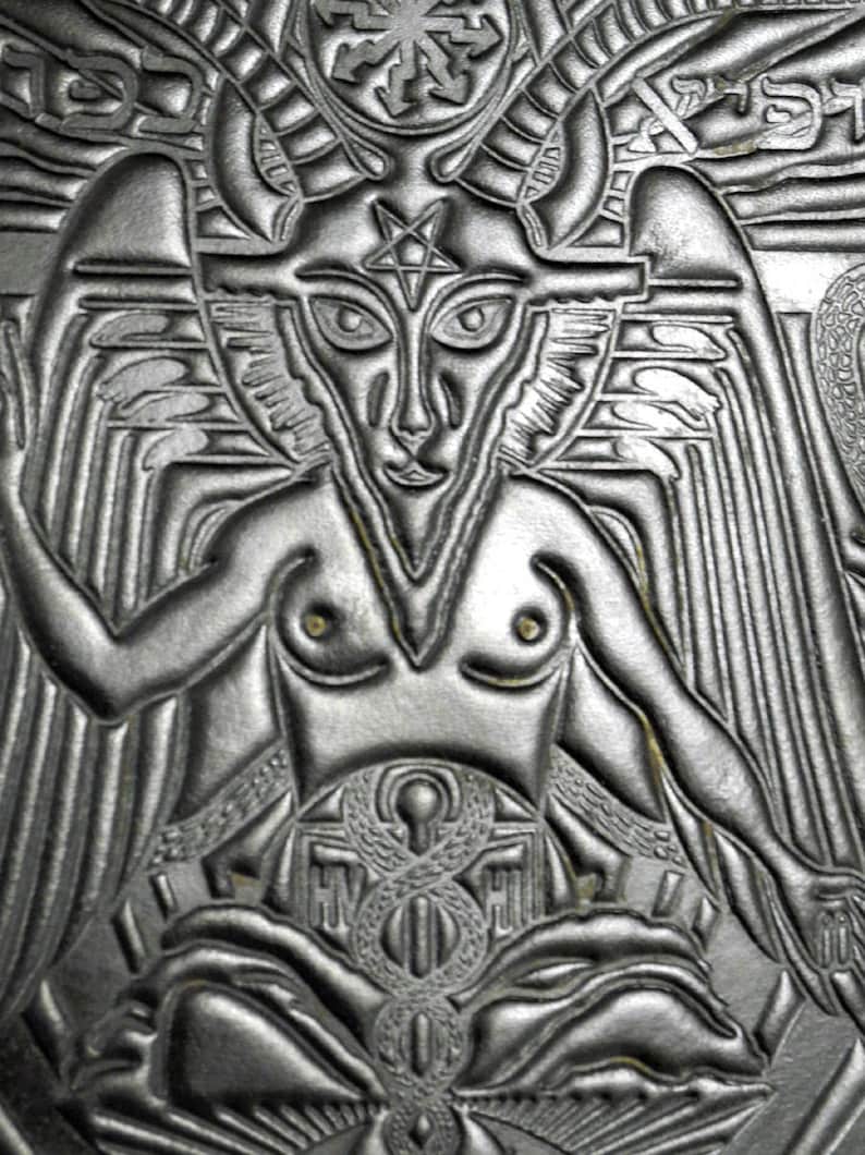 Peut inclure: Un motif en cuir gaufr&eacute; noir et blanc repr&eacute;sentant une figure ail&eacute;e avec un pentagramme sur le front. La figure est assise les jambes crois&eacute;es et a un motif en forme de serpent sur ses genoux.