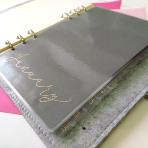 Set di divisori mensili per agende e planner di misura A5, Personal e Pocket. Colori disponibili sono grigio, rosso, bianco e rosa. I dettagli dei mesi sulle tab sono di colore oro rosa.