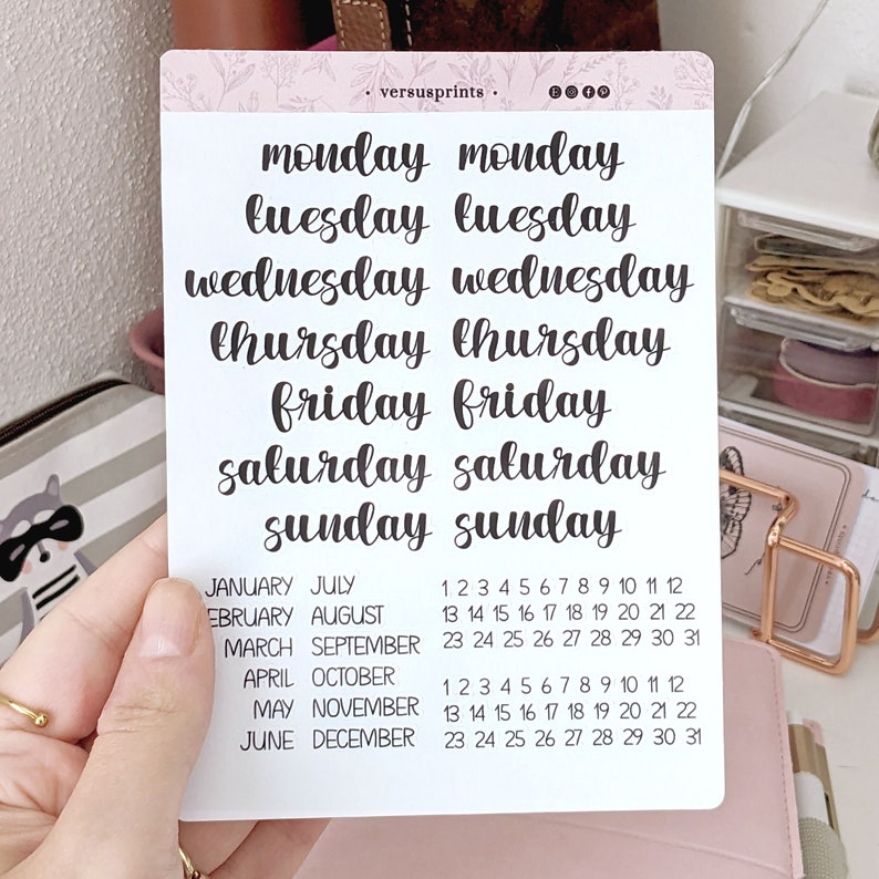 May include: A set of printable planner stickers with the days of the week written in a cursive font. The stickers are white with black text. The days of the week are Monday, Tuesday, Wednesday, Thursday, Friday, Saturday, and Sunday. The stickers also include a calendar with the months of the year and the numbers 1 through 31.