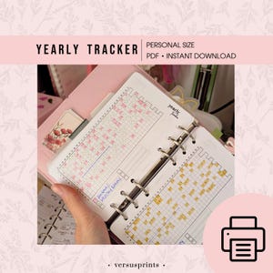 Könnte beinhalten: Ein persönlicher Jahresplaner mit rosa und gelben Rasterlayouts. Der Planer enthält den Text "Yearly Tracker" und "Personal Size PDF Instant Download". Der Planer ist auf eine Doppelseite mit rosa und gelben Quadraten geöffnet.