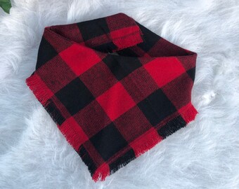 thumbnail image 2 of A Llama Wearing A Red And Black Plaid Scarf Stands In A Field Of Fallen 2 of 14