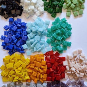 Puede incluir: Surtido de pequeñas baldosas de mosaico cuadradas en varios colores, incluyendo negro, blanco, azul, azul claro, verde, turquesa, amarillo, naranja, rojo, beige, gris y morado.