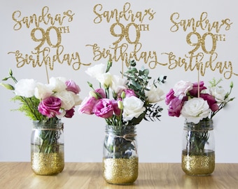 Puede incluir: Tres tarros de cristal Mason con purpurina dorada, flores y un adorno de purpurina dorada "Sandra's 90th Birthday" en cada uno.