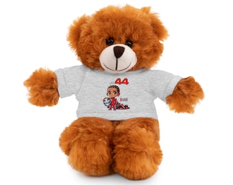 May include: A brown teddy bear wearing a grey t-shirt with a cartoon image of a race car driver and the number 44.