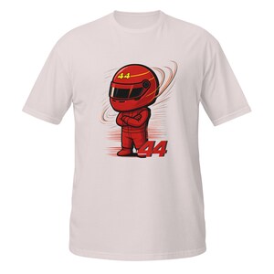 white tee flat-lay with the red chibi racer graphic and "Lewis Hamilton" text, front view with visible fabric texture.