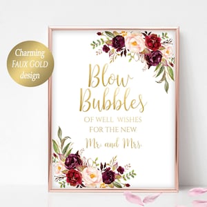 Op de afbeelding: Een printbaar bord met een faux-gouden ontwerp en bordeauxrode en blush-kleurige bloemenaccenten. Het bord zegt "Blaas bubbels voor de nieuwe bruid en bruidegom."