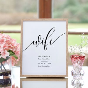 Könnte beinhalten: Ein weiß gerahmtes Schild mit dem Wort "wifi" in Kursivschrift. Das Schild enthält auch die Wörter "Netzwerk" und "Passwort" mit Linien darunter, auf denen Benutzer ihren Netzwerknamen und ihr Passwort eintragen können.