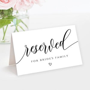 May include: White card with black calligraphy that reads "reserved" and "for bride's family" with a small heart symbol.