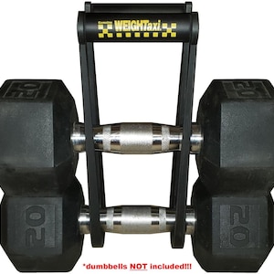 May include: Black metal dumbbell rack with a yellow and black handle. The rack is designed to hold two dumbbells. The text "Genuine WEIGHTaxi" is printed on the handle. The text "*dumbbells NOT included!!!*" is printed below the rack.