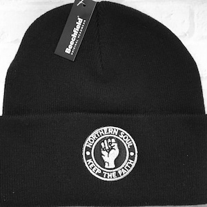 May include: Black beanie with a white embroidered logo that says "Northern Soul Keep The Faith" with a raised fist in the centre.