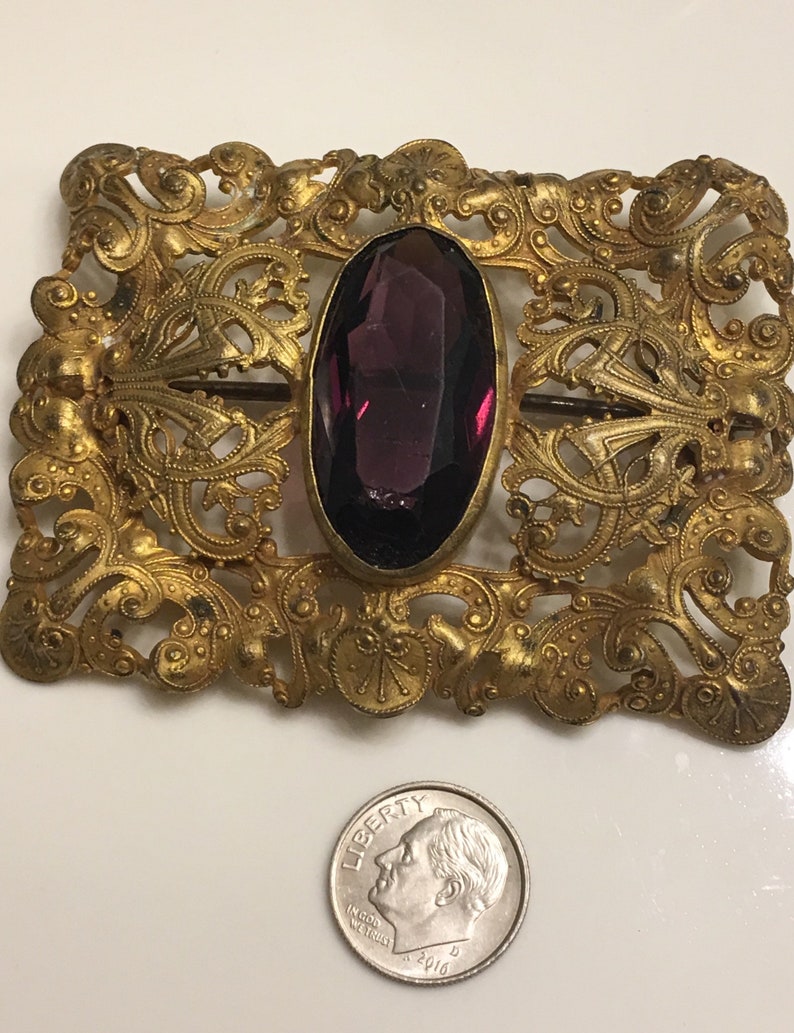 Art nouveau ornate brass brooch or belt buckle with a chipped amethyst glass in the middle circa 1900s image 2