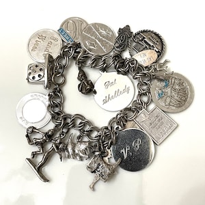Vintage sterling charm bracelet with 20 PCs of charms in a double link sterling bracelet 7 inches in length. Circa 1970’s