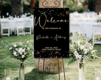 Puede incluir: Un letrero de bienvenida de boda negro con texto y detalles dorados. El letrero dice "Welcome to the Wedding of Rochelle & Anthony, May 20, 2025, Fort Worth, Texas". El letrero está sobre un caballete marrón, con arreglos florales en primer plano.