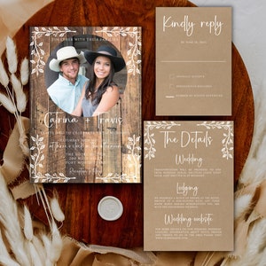 K&ouml;nnte beinhalten: Rustikales Hochzeitseinladungs-Set mit einem Foto des Paares auf einem Holzgrund. Die Einladung und die Begleitkarten sind mit wei&szlig;er Schrift und floralen Verzierungen versehen. Enth&auml;lt eine RSVP-Karte.