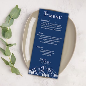 May include: A blue wedding menu card with white text and illustrations of mountains and trees. The menu includes starters, main courses, and desserts. The text at the bottom reads "Sarah and Joshua May 20, 2025".