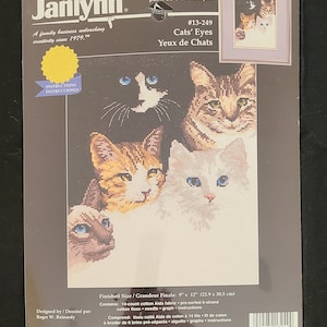 May include: A counted cross stitch pattern featuring four cats with different coloured fur. The pattern is titled "Cats' Eyes" and is from Janlynn, a family business unleashing creativity since 1979. The finished size is 9 inches by 12 inches.
