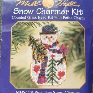 May include: A counted glass bead kit for making a snowman ornament. The kit includes a petite charm and the text "MHSC28-Pine Tree Snow Charmer".