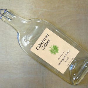May include: A clear glass wine bottle with a cork stopper and a label that reads "Cakebread Cellars Napa Valley Sauvignon Blanc 2008".