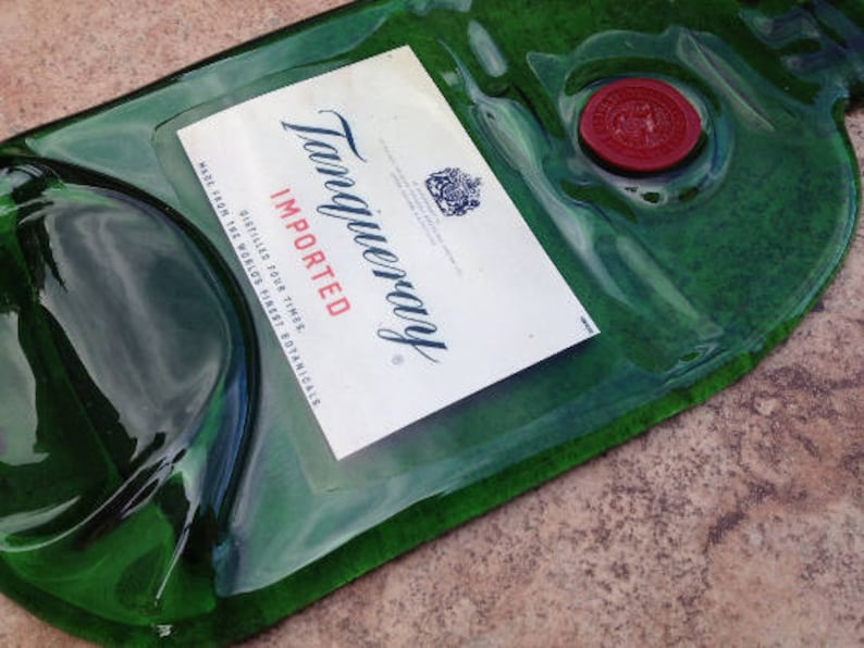 Pode incluir: Uma garrafa de vidro verde com um r&oacute;tulo que diz "Tanqueray Imported Gin, Distilled Four Times, The World's Finest Botanicals". A garrafa tem um selo de cera vermelha.
