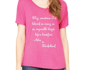 May include: Pink women's t-shirt with a white graphic print of a quote from Alice in Wonderland: "Why, sometimes I've believed as many as six impossible things before breakfast. - Alice in Wonderland"