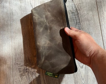 May include: A brown canvas zippered pouch with a green label that reads "Katadhin Gear" and "Made in USA".