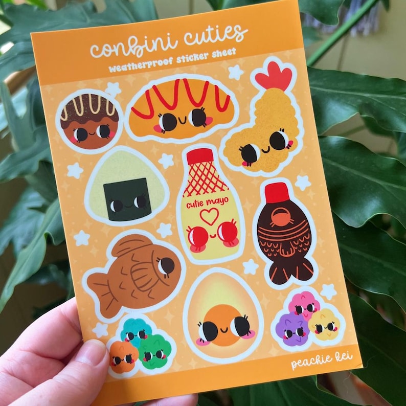 Peut inclure: Une planche d'autocollants color&eacute;s et r&eacute;sistants aux intemp&eacute;ries avec des illustrations de style dessin anim&eacute; d'aliments japonais. Les autocollants comprennent un beignet, un croissant, une crevette tempura, onigiri, une bouteille de mayo, une p&acirc;tisserie en forme de poisson, une bouteille de sauce soja, un &oelig;uf dur et un groupe de l&eacute;gumes.