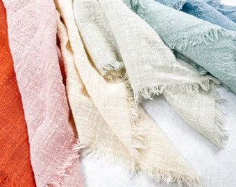 May include: A set of six fabric swatches in various shades of blue, green, pink, and orange. The fabric has a rough, textured surface and frayed edges.