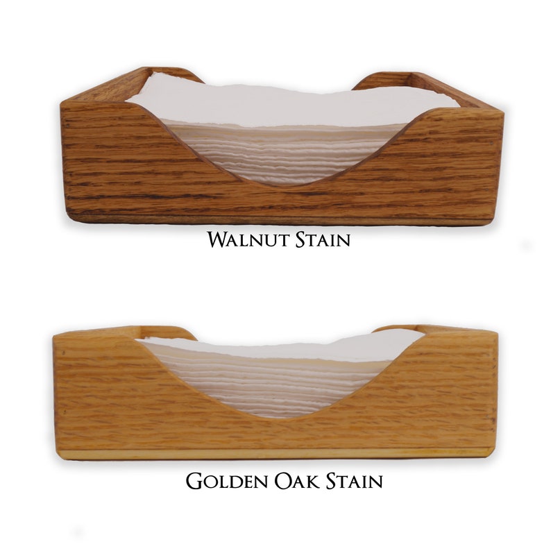 May include: Two wooden napkin holders, one stained walnut and the other golden oak. Both holders have a curved opening for napkins.