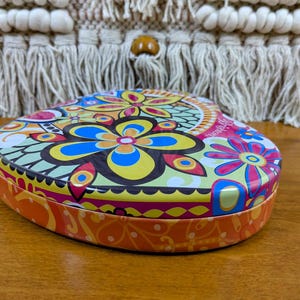 May include: A white ceramic mug with a black handle and the text "But First, Coffee" in a black, handwritten-style font. The mug is on a white surface.