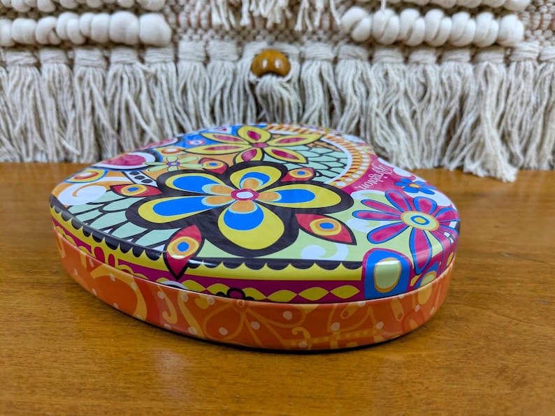 May include: A white ceramic mug with a black handle and the text "But First, Coffee" in a black, handwritten-style font. The mug is on a white surface.