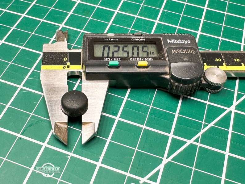 May include: A black digital caliper measuring a small black round object. The caliper reads 0.2505 inches.