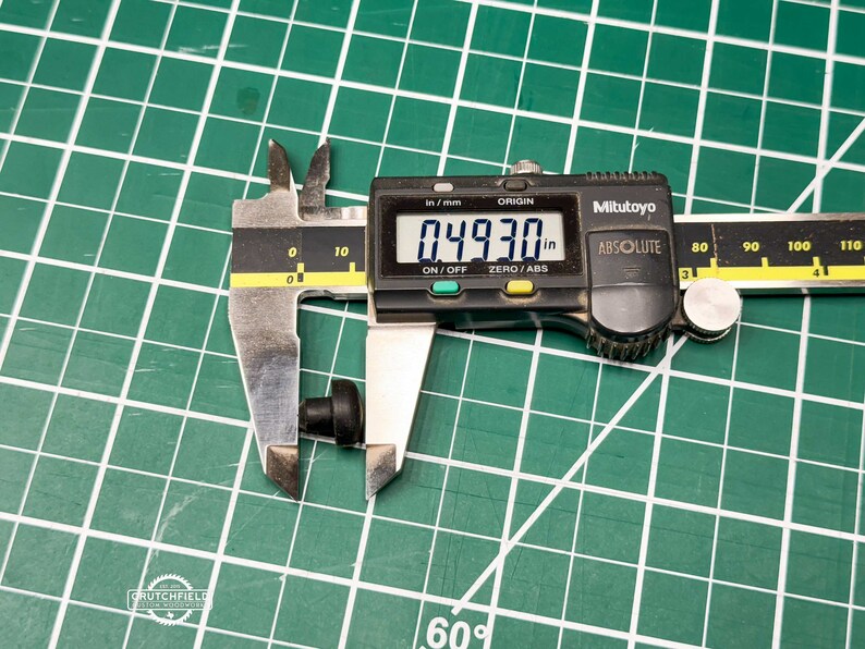May include: A black digital caliper measuring a small black object. The caliper reads 0.4930 inches.