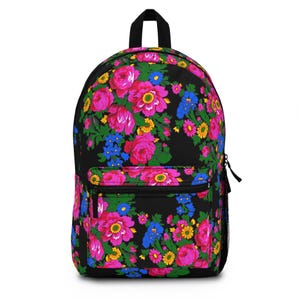 May include: Black backpack with a vibrant floral pattern. The design features large pink roses, blue and yellow flowers, and green leaves. The backpack has a front pocket and a black zipper.