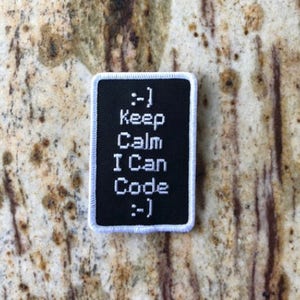 May include: Black and white embroidered patch with the text "Keep Calm I Can Code" and the symbols ":-)" at the top and bottom.