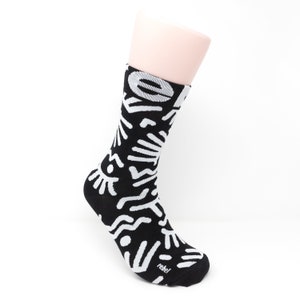 May include: Black and white patterned socks with a white "rebel" logo on the bottom.