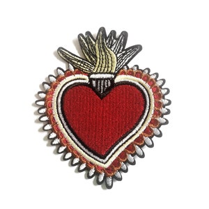 May include: Embroidered iron-on patch of a red heart with a gold and white flame design. The heart is surrounded by a white, gold, and red decorative border.