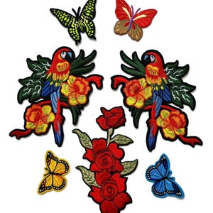 May include: Embroidered patches featuring colorful parrots, butterflies, and roses. The parrot patches have red, yellow, blue, and green details. The butterfly patches are yellow, red, and blue. The rose patch is red.