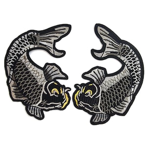 May include: Two embroidered koi carp patches. The fish are black, grey, and yellow with detailed stitching. Each patch has a black border, set against a white background. Ideal for customising clothing or accessories. Each patch is approximately 15 cm in length.