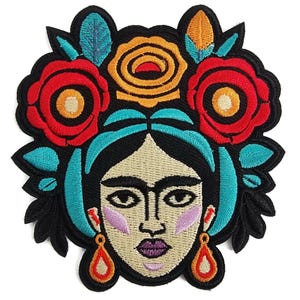 Op de afbeelding: Gestikt patch met een kleurrijk portret van een vrouw met een bloemenkrans. De vrouw heeft donker haar, een lichte huidskleur en draagt grote, oranje oorbellen. De bloemen zijn rood, oranje en blauw.