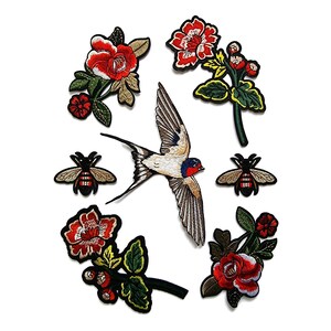 Könnte beinhalten: Gestickte Aufnäher mit einer fliegenden Schwalbe, roten Rosen und Bienen. Die Aufnäher haben detaillierte Stickereien mit roten, grünen, schwarzen und weißen Farben. Geeignet zum Dekorieren von Kleidung oder Accessoires.