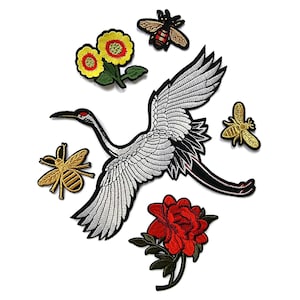 May include: Embroidered patches featuring a crane, bees, sunflowers, and a red rose. The crane patch is white with black accents. The bee patches are gold and black. The floral patches have green leaves.