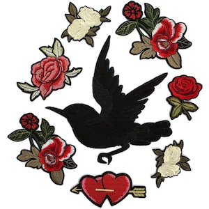 Puede incluir: Una colección de parches bordados que presenta un gran pájaro negro en vuelo en el centro, rodeado de varios motivos florales que incluyen rosas rojas y blancas con hojas verdes, y un corazón rojo atravesado por una flecha dorada abajo.
