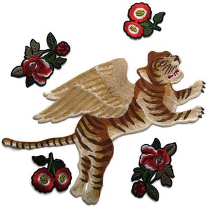 May include: Embroidered patches featuring a winged tiger with brown and tan stripes, and several floral designs with red and green accents. The patches are likely for clothing or accessories.